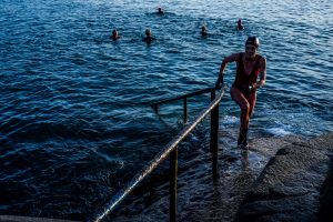 DUBLIN, IRELAND - MARCH 24: A swimmer is seen climbing out of the icy water at sunrise at the "Forty Foot", a popular swimming hole drenched in history at Sandycove on March 24, 2021 in South Couny Dublin. Since the Pandemic started last year and many businesses had to shut including gyms and pools many more locals have turned to sea swimming. (James Forde for The Washington Post)